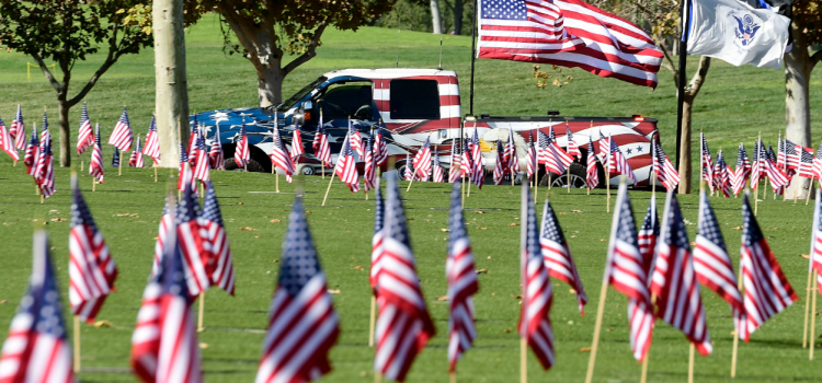 Voluntarios colocan banderas en la ceremonia del día de los caídos